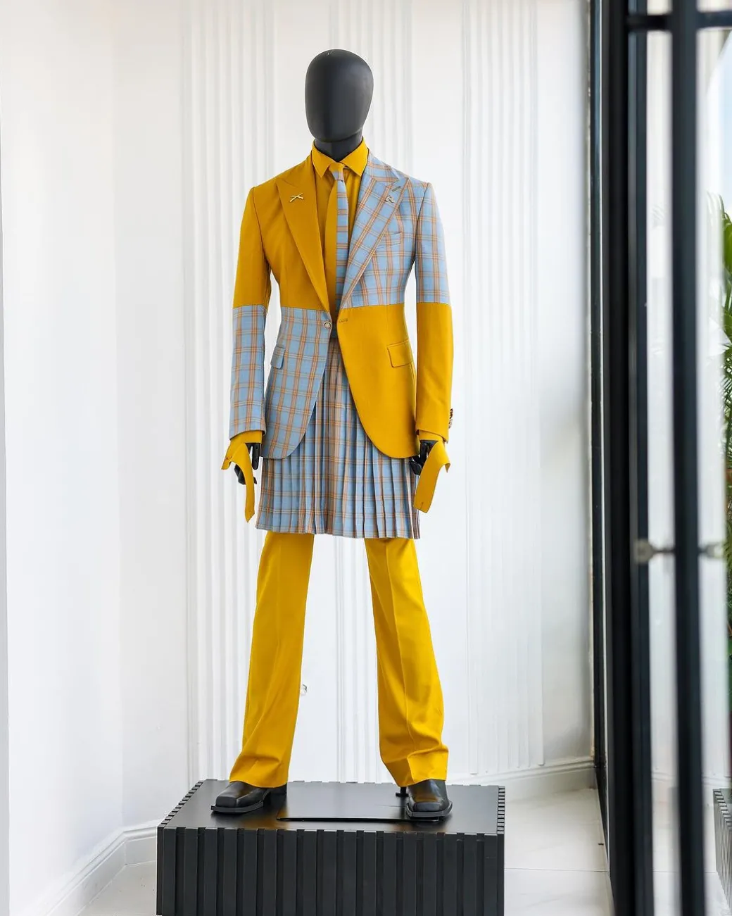 A “Square Shattered” yellow and broken tartan check in sapphire blue mix peak lapel suit