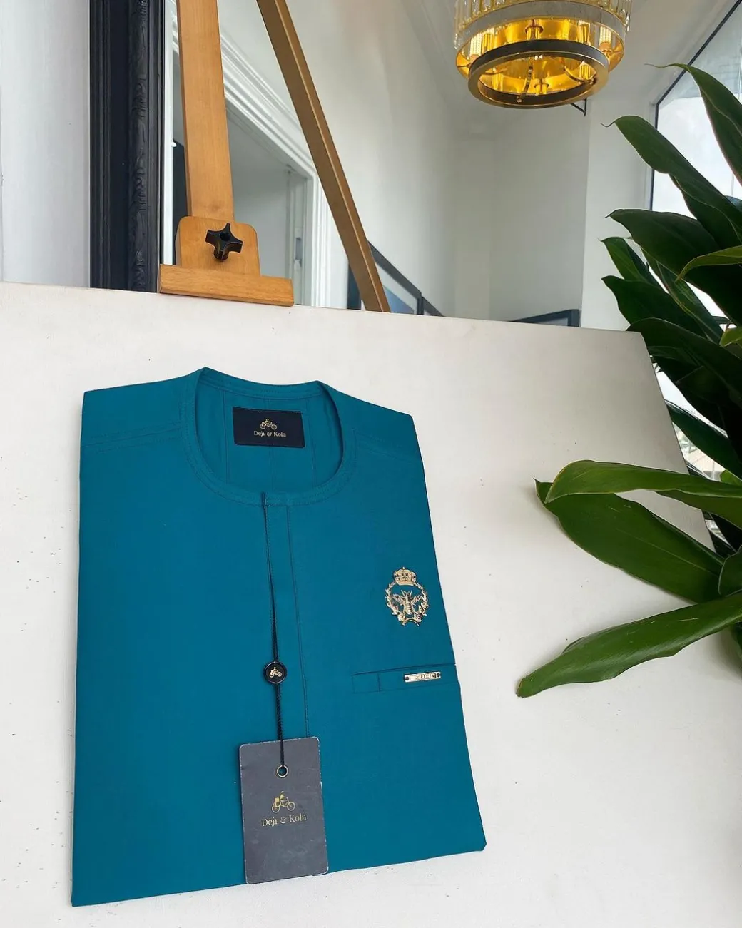 A teal green, tiny flap, and gold bee crown detail an African traditional senator kaftan native.