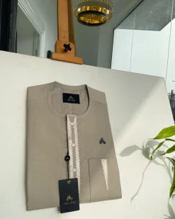 A tortilla brown, connected triangle front flap, and pocket embroidery detailing African traditional senator Kaftan native
