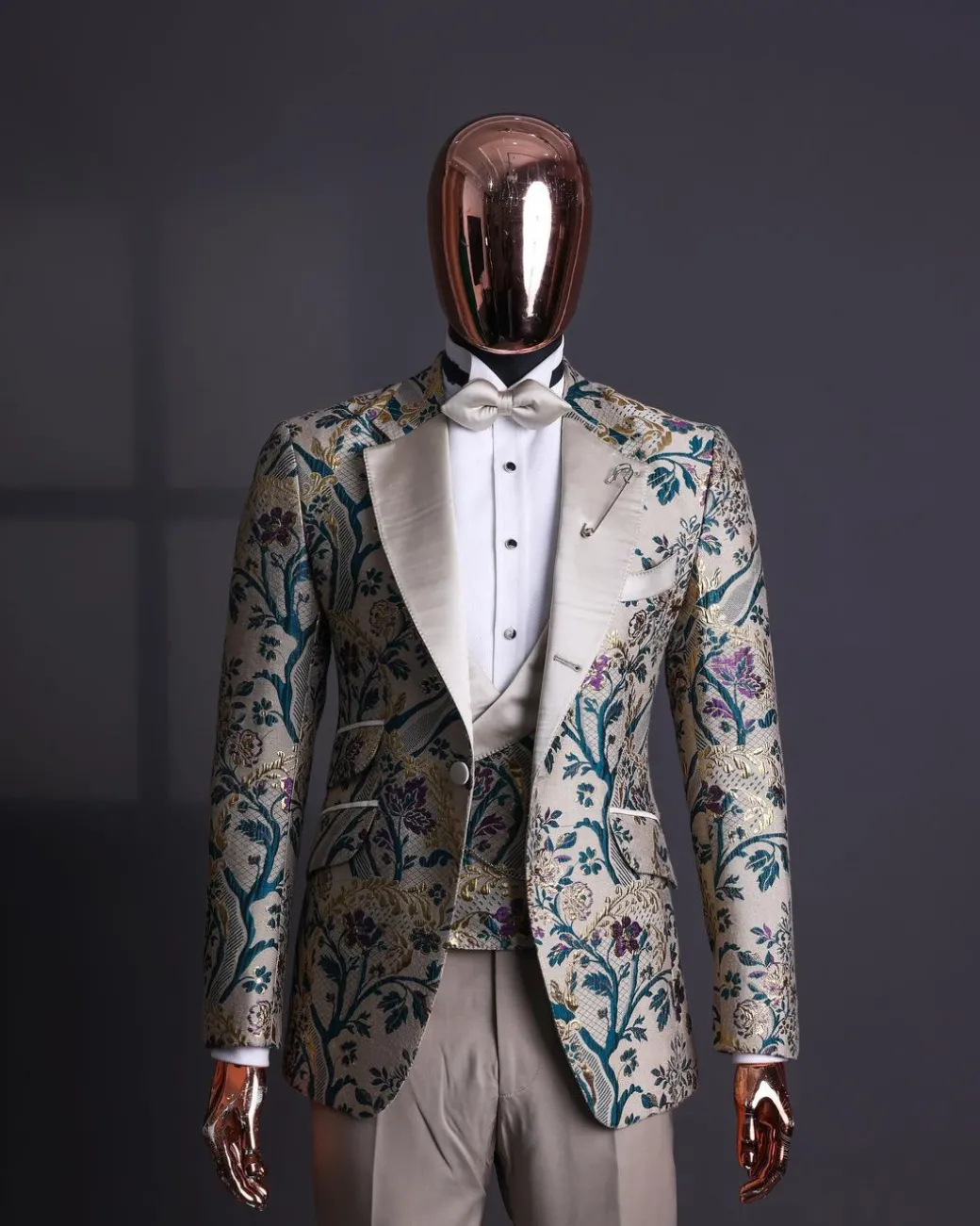 A Tortilla brown, emerald green, gold and splash of burgundy metallic floral jacquard peak lapel tuxedo suit