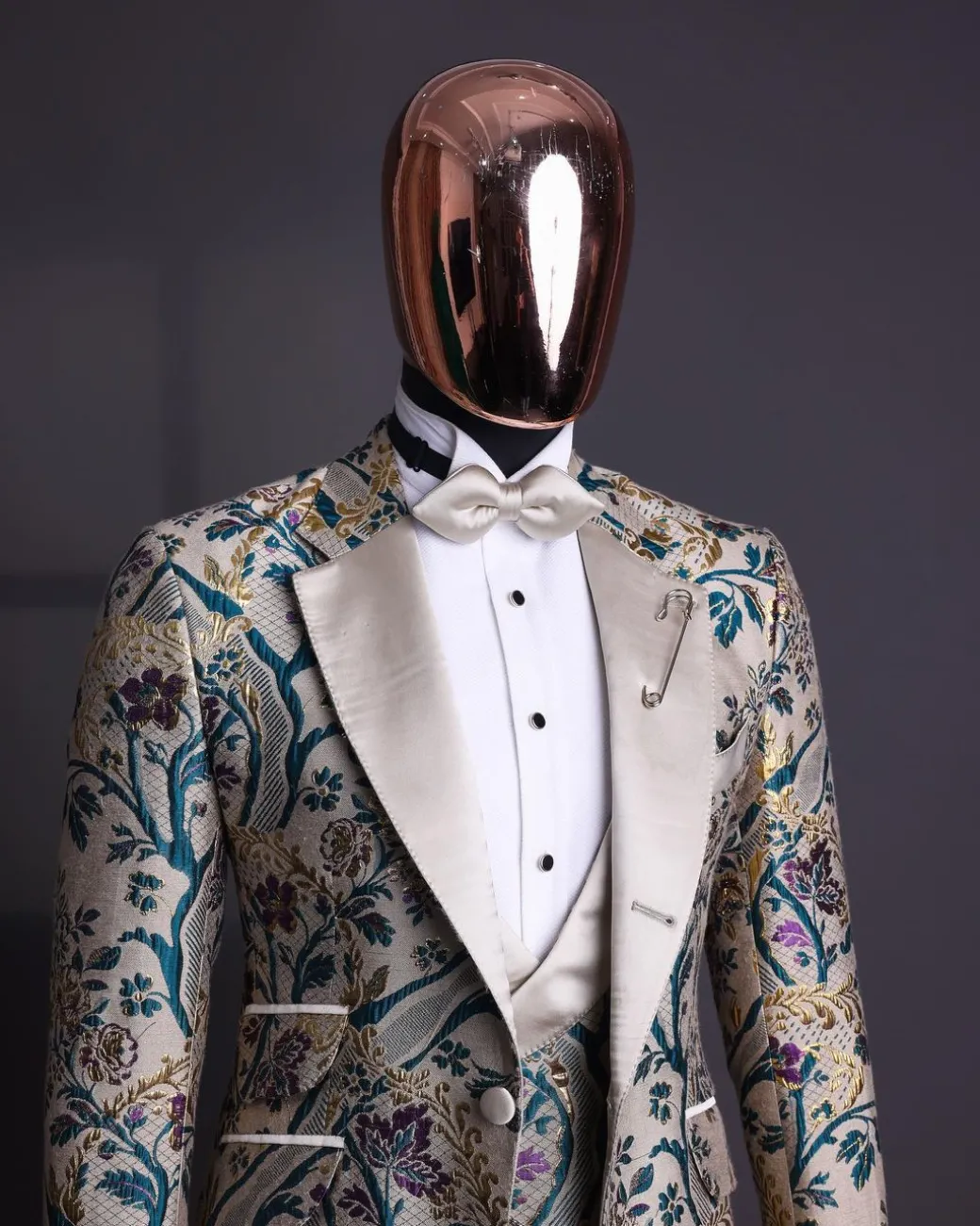 A Tortilla brown, emerald green, gold and splash of burgundy metallic floral jacquard peak lapel tuxedo suit