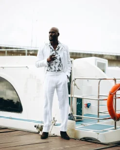 A White “Tropicana” Linen Overcoat & Wide Cut Pant Trousers.
