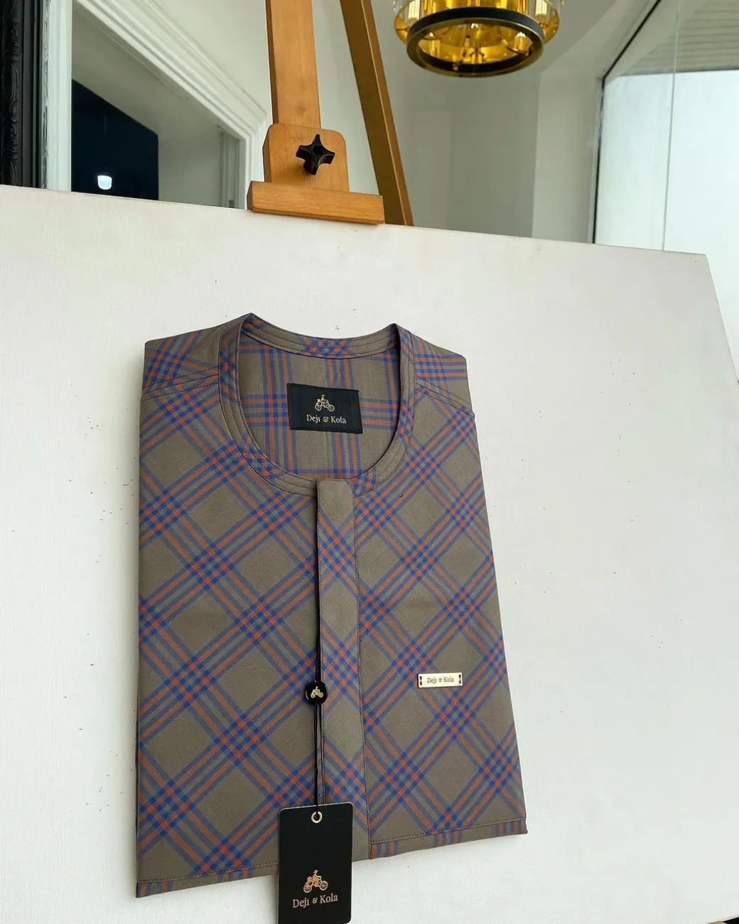 A windowpane tortilla brown with orange and navy blue stripes, a front flap detailing African traditional senator kaftan native.