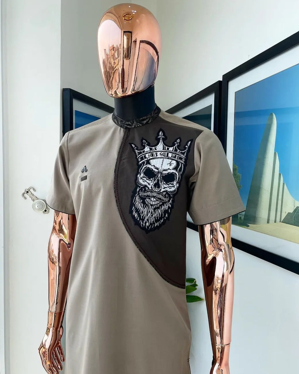 An almond ivory and cedar brown, black and gold metallic Jacquard neck and crown skull embroidery punk biker patch detailing African traditional senator Kaftan native.