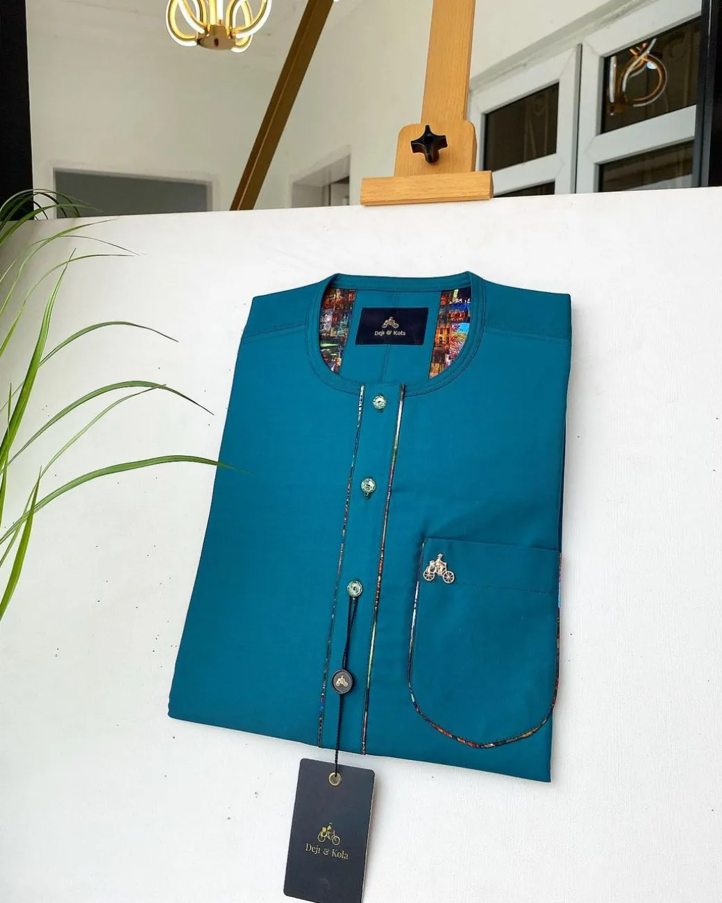 An emerald green with a Swarovski stone button and lower cylinder-shaped African Kaftan