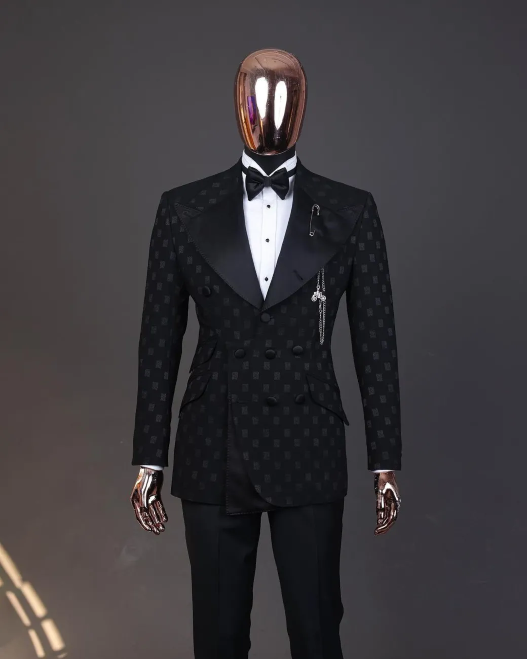 An Inverted “Pirate”, knitted, charcoal black with distributed square pattern jacquard peak lapel, 9 button tuxedo suit.