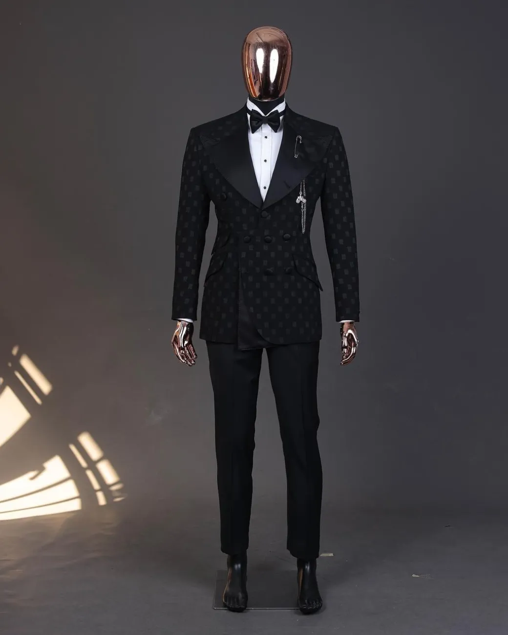 An Inverted “Pirate”, knitted, charcoal black with distributed square pattern jacquard peak lapel, 9 button tuxedo suit.