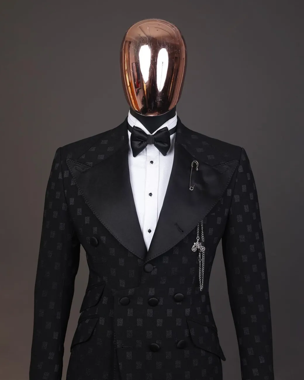 An Inverted “Pirate”, knitted, charcoal black with distributed square pattern jacquard peak lapel, 9 button tuxedo suit.