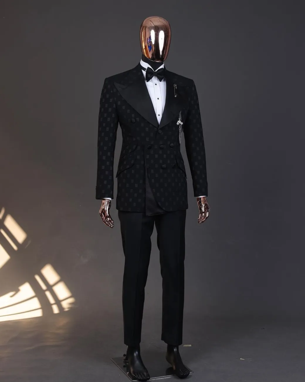 An Inverted “Pirate”, knitted, charcoal black with distributed square pattern jacquard peak lapel, 9 button tuxedo suit.