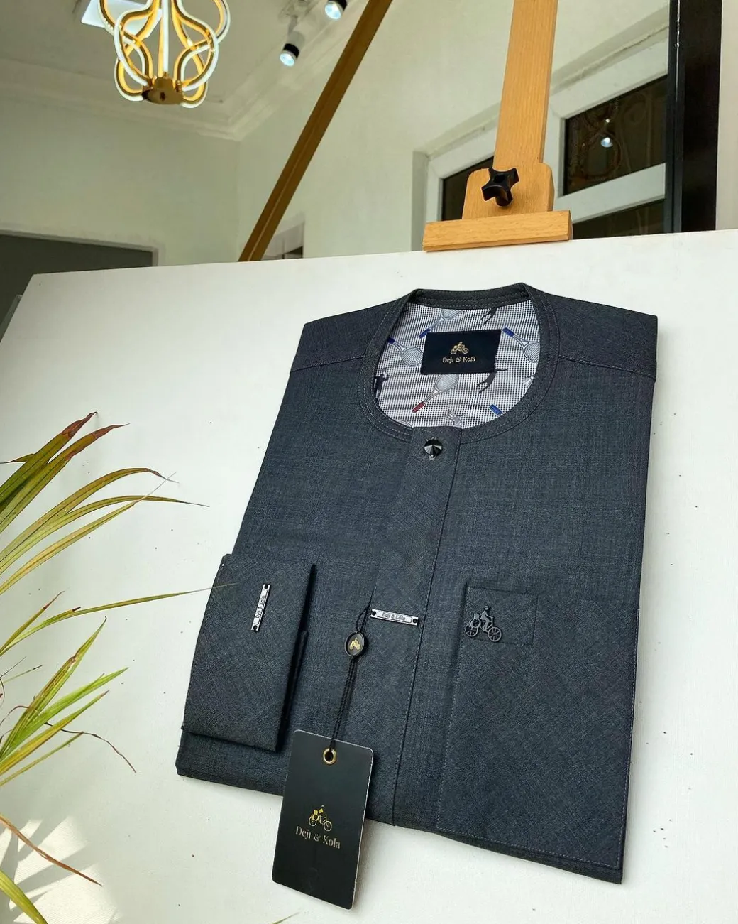 An Irish Grey African kaftan with a black Swarovski button and metal detailing