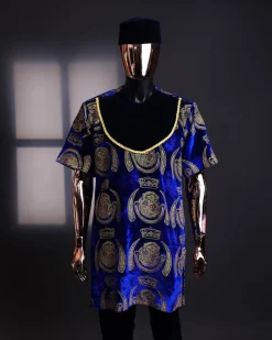 An “isiagu” gold, blue with matching fringe details, short sleeve, hat and velvet pant African traditional native.