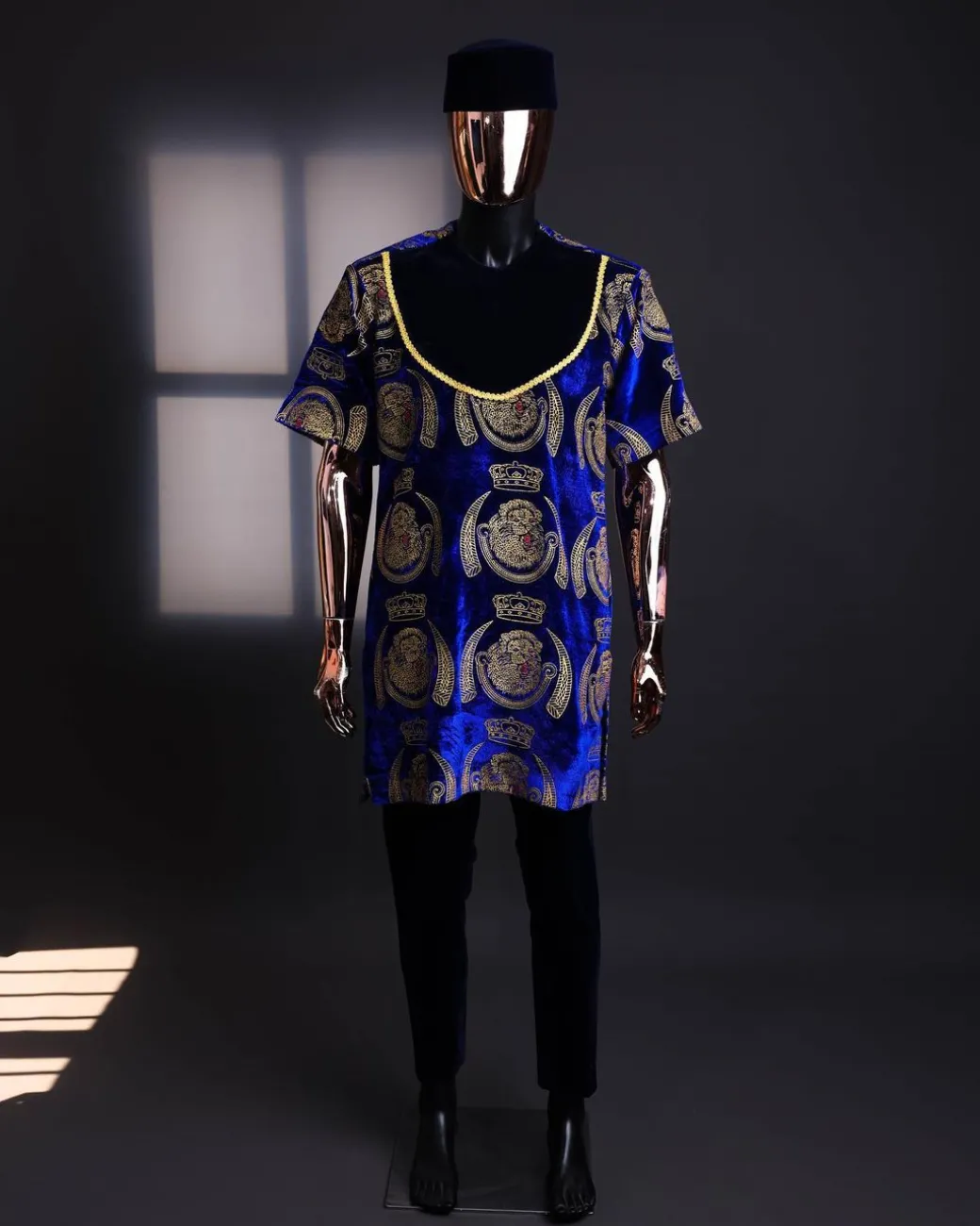 An “isiagu” gold, blue with matching fringe details, short sleeve, hat and velvet pant African traditional native.