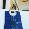An ivory and blue check kaftan with an ivory-layered front section is a traditional African kaftan