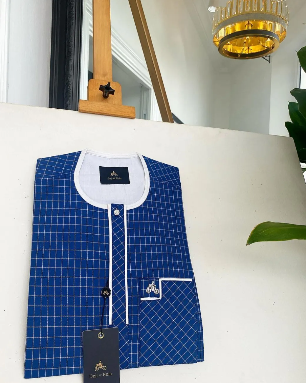 An ivory white and blue check, clear view transparent Swarovski buttons, front flap details African traditional senator kaftan native.