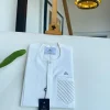An Ivory White, clear view silver Swarovski buttons, ruffle pocket details, African traditional senator kaftan native.