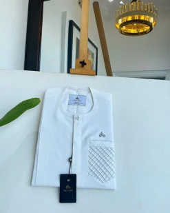 An Ivory White, clear view silver Swarovski buttons, ruffle pocket details, African traditional senator kaftan native.