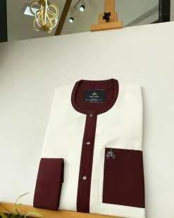 An Ivory white kaftan with a burgundy mix flap, pocket, and cuff design African Kaftan
