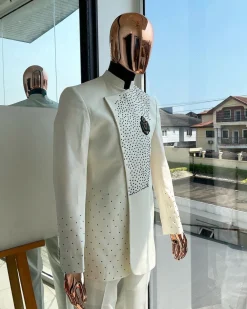 An ivory white, slide cut, navy blue dispersed safari suit with clustered Swarovski stone detailing