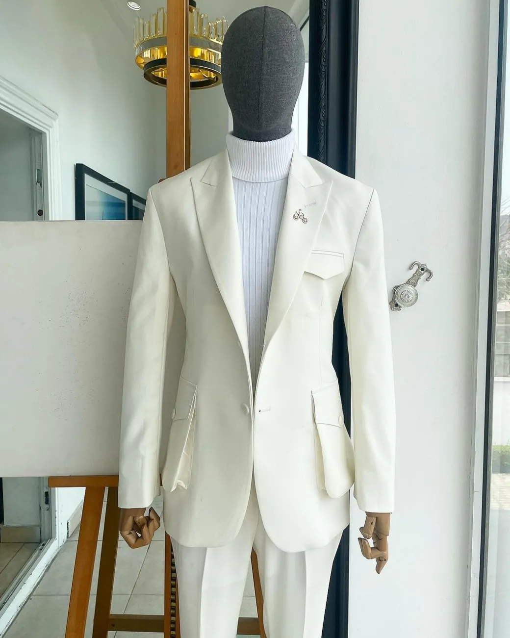 An Ivory white, x-large combat patch pocket, peak lapel suit