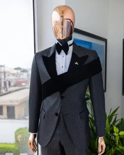 An “Octopus” black inverted square patterned jacquard tuxedo with left strap black velvet peak lapel suit
