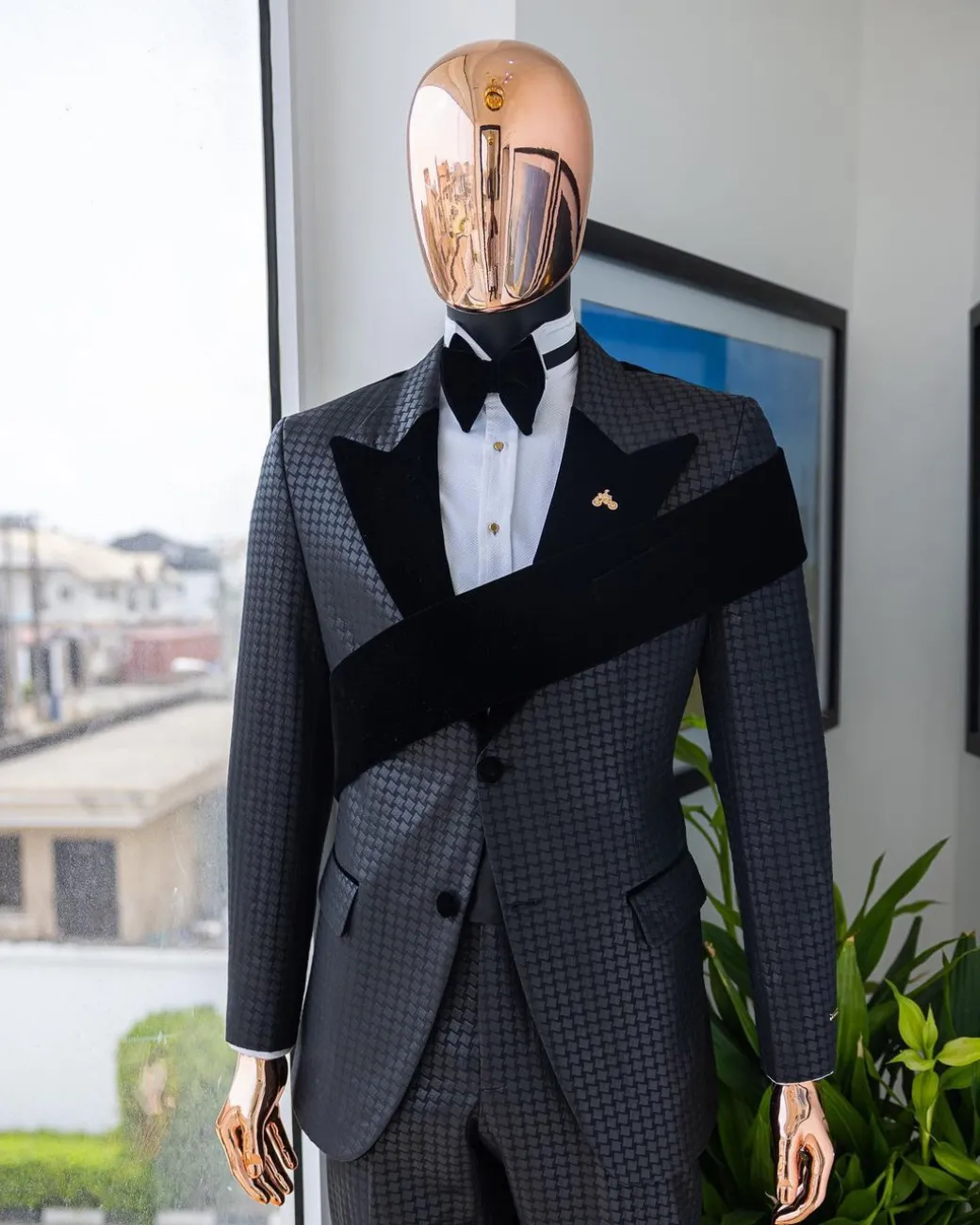 An “Octopus” black inverted square patterned jacquard tuxedo with left strap black velvet peak lapel suit