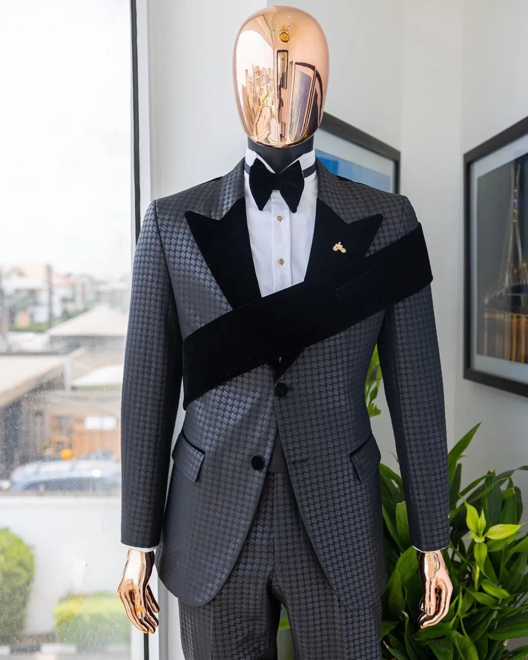 An “Octopus” black inverted square patterned jacquard tuxedo with left strap black velvet peak lapel suit